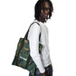 Person holding a camouflage bag on a white background
